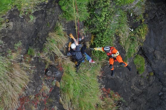 image of rescuer approaching cliff